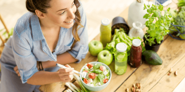 Woman eating salad smiling