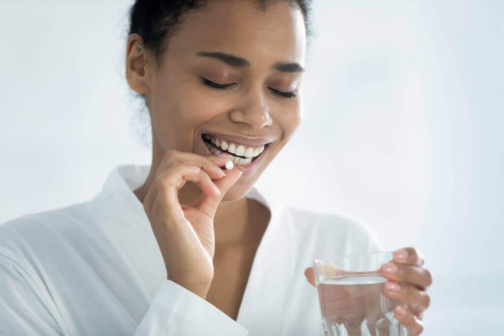 Smiling woman taking supplements